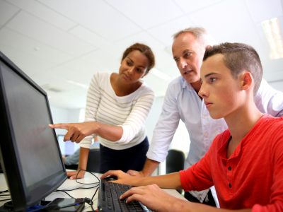 teacher with student at a computer